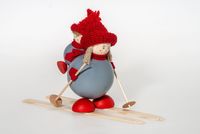 Tonttu äiti ja poika reppuselässä suksilla